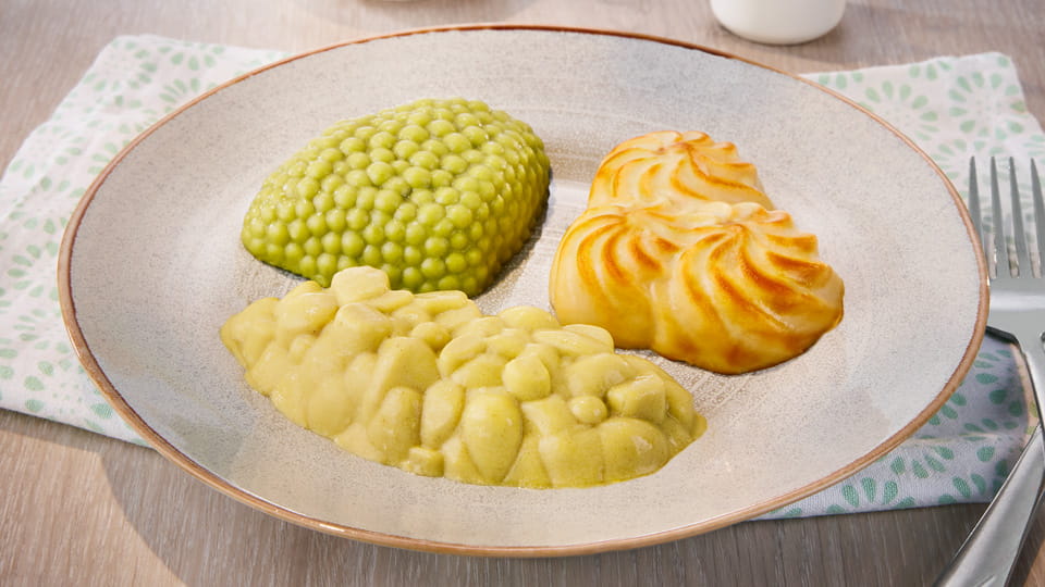 Püriertes Menü auf einem Teller mit geformtem Gemüse, Kartoffeln und Fleisch