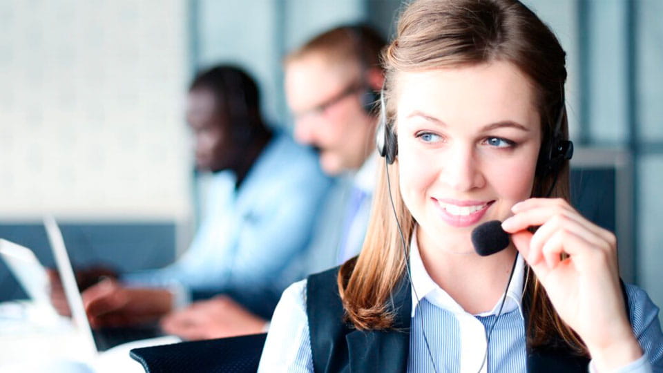 Lächelnde Kundenberaterin mit Headset am Telefonieren